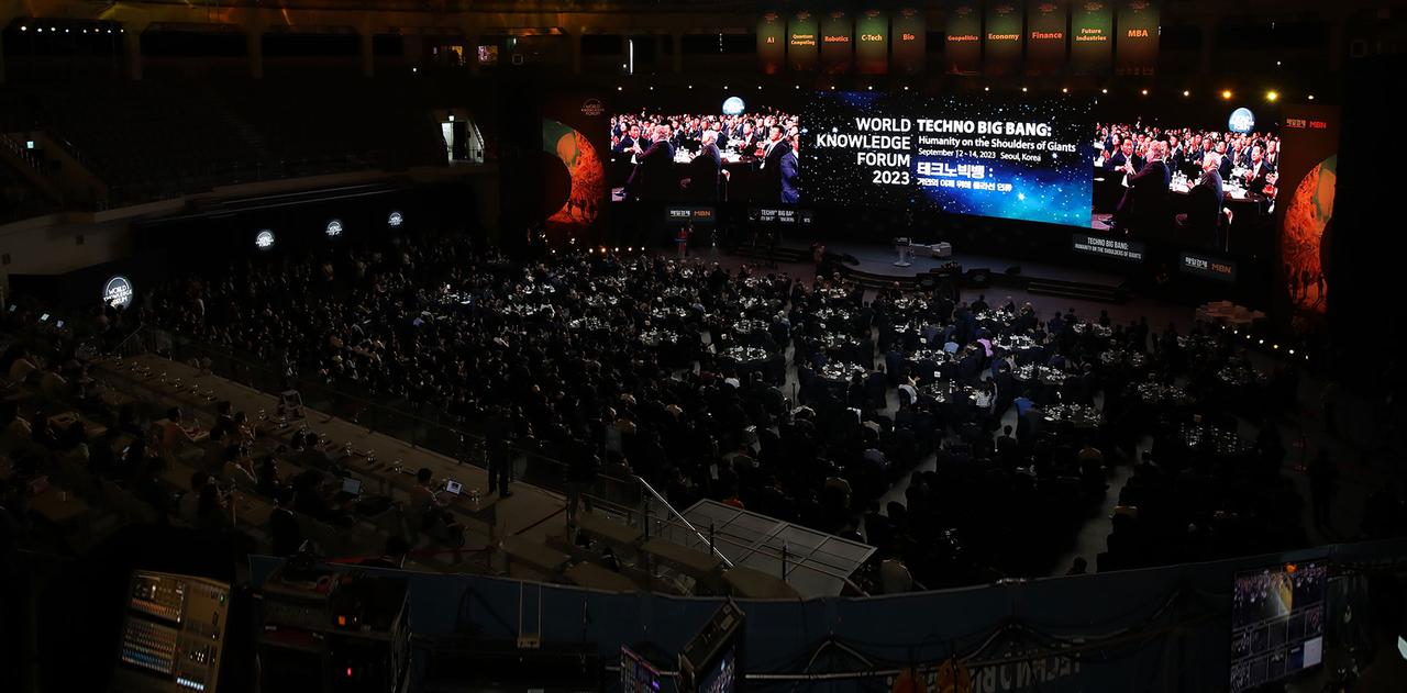 세계지식포럼2023 테크노빅뱅 행사장 전체 모습, 참석자로 가득 찬 객석과 대형 스크린 보임